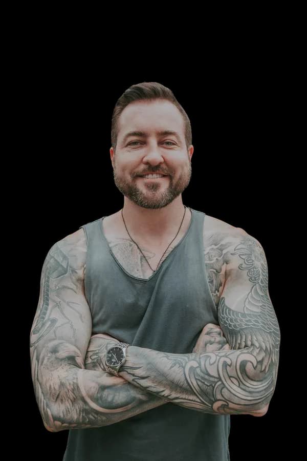 John Anthony, arms folded, smiling